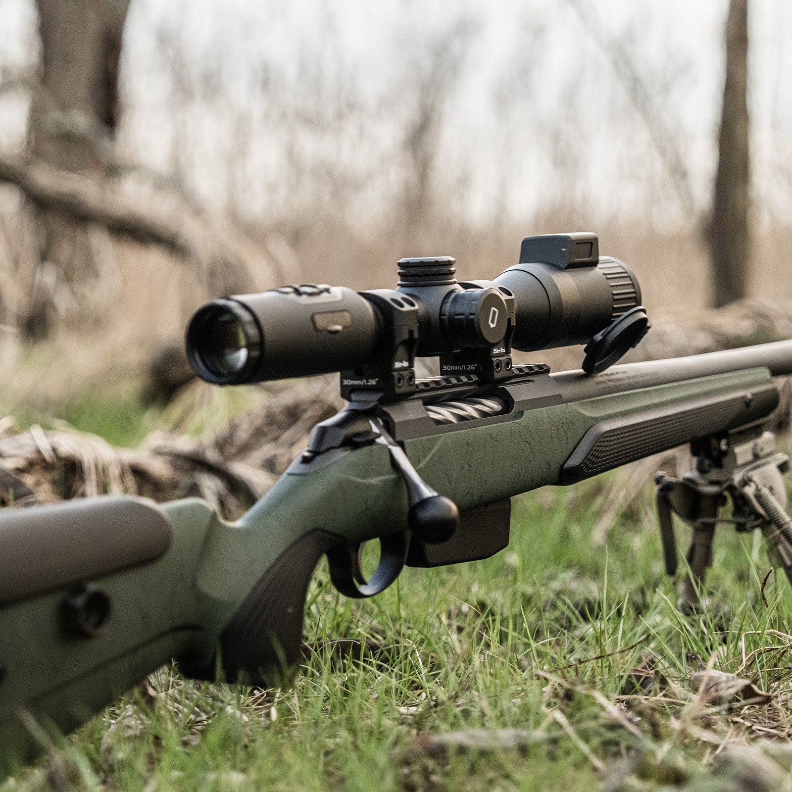DNT Optics ZULUS 4K mounted on a precision bolt-action rifle with bipod in a woodland setting